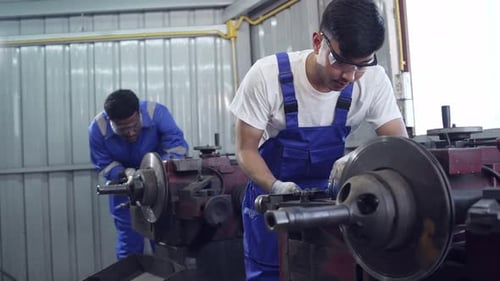 Men working on machinery inside of workshop