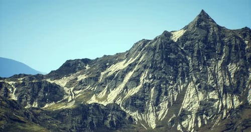 Majestic Mountain Peak Rises Under Clear Blue Sky in Remote Location