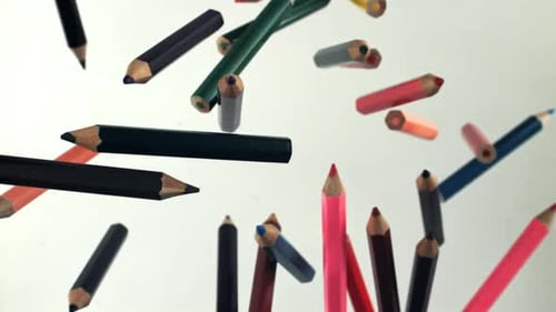 Multicolored Pencils Fly Up and Fall on a White Background Filmed on a Highspeed Camera at 1000 Fps