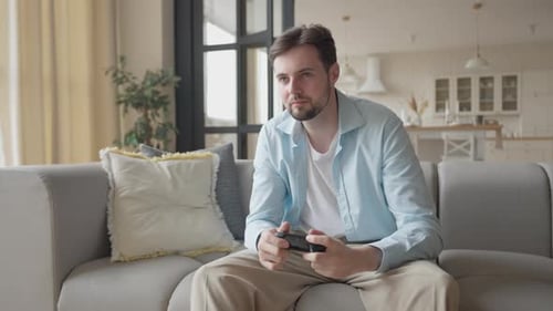 Upset Student Drops Game Controller After Losing Sitting On Couch At Home