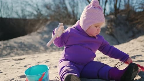 Toddler Enjoys Playful Moments in the Sand While Exploring a Park on a Sunny Day