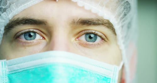 close up portrait of a surgeon or doctor with mask and headset ready for operation in hospital or