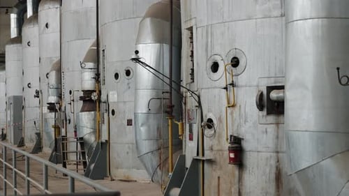 Dolly Shot of Large Metal Tanks in Industrial Setting