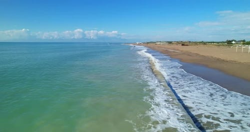 The Drone Flies Along the Shore Over the Foaming Waves