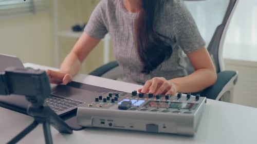 Woman Using Audio Mixing Equipment for Music Production