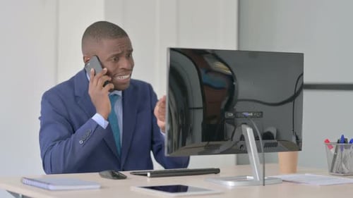 Angry Man Talking on the Phone in Office
