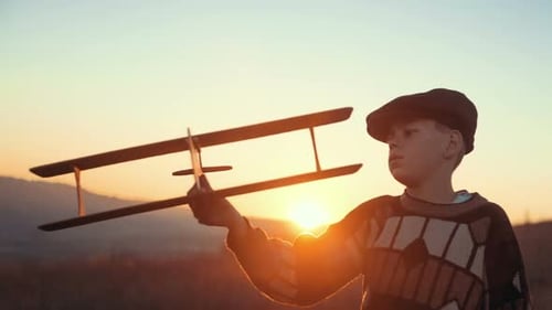 Child Holding a Toy Airplane in a Field