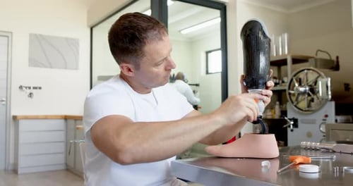 Techniker im Prothesenlabor passt künstliche Beine an und konzentriert sich auf präzise Passform