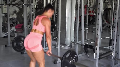 Attractive Sporty Woman Weightlifting Training with Barbell in the Gym