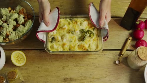 The Chef Serves the Vegetable Casserole with Cheese Hot Using Oven Mitts to Avoid Getting Burned