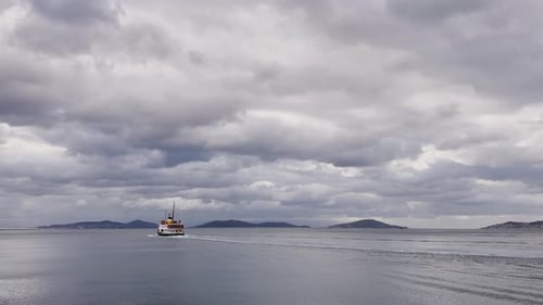 Ferries, boats, sailboats, birds, breakwater, pier, waves in the sea in cloudy weather in autumn