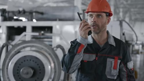 Factory Worker Communicates Using Radio