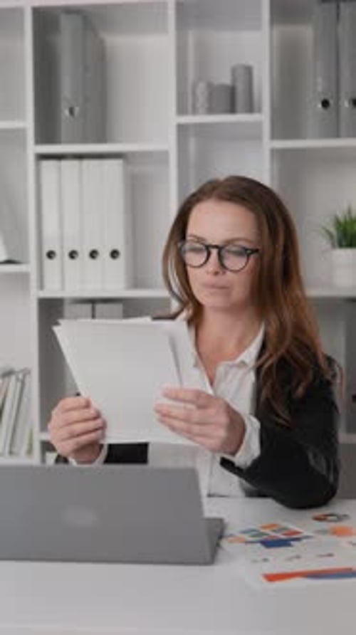 Businesswoman in Office Carefully Analyzing Financial Reports and Revenue Growth Strategies Her