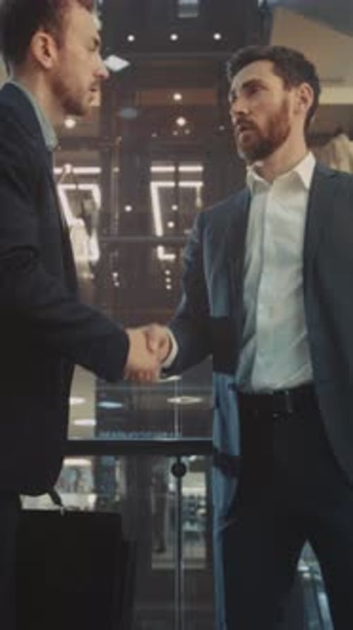 Businessmen Shaking Hands and Talking in Modern Building