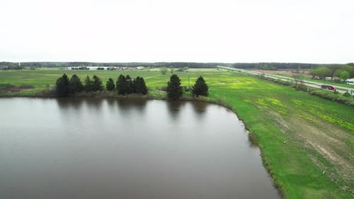 Flying Over Lake With a Highway on Right Side of Frame in Early Spring After a Storm. Water on the G