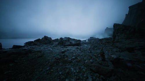 Las olas chocan mientras un guardabosques observa la tormenta que se acerca durante la puesta de sol