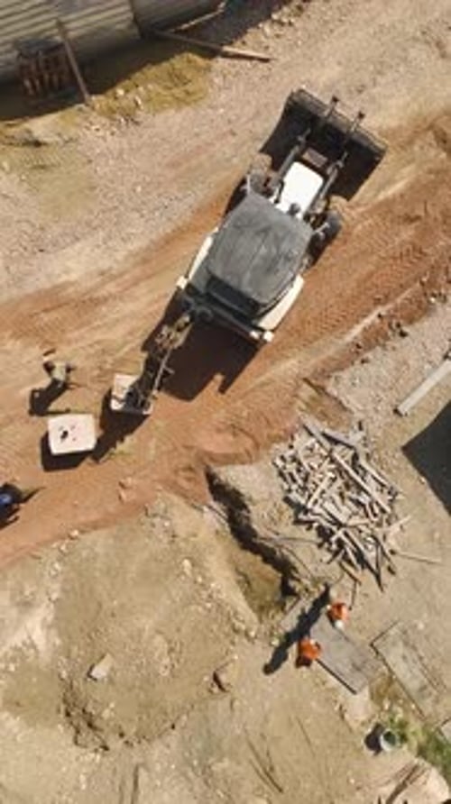 Vertical Video Aerial Landscaping Perspective on Tractor Preparing Site for Residential Complex
