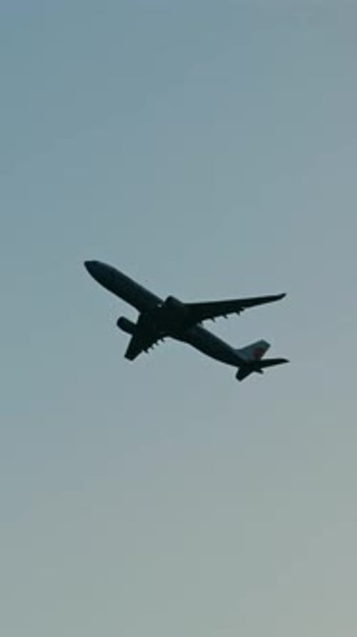 Passenger Jet Ascending in Blue Cloudy Sky