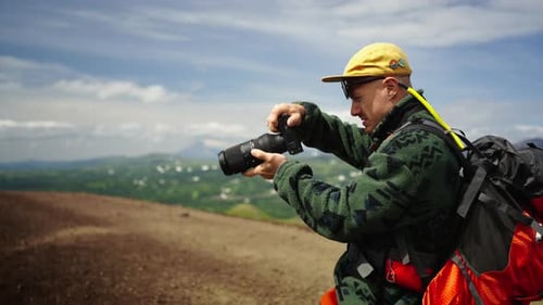 Handsome Young Adult Man With Backpack Taking Pictures Of Scenery In Mountains Portrait