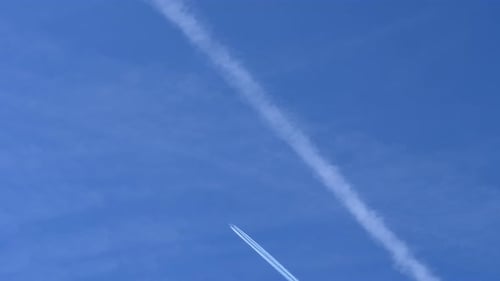4K Airplane Contrail Flightpath in Clear Blue Sky.