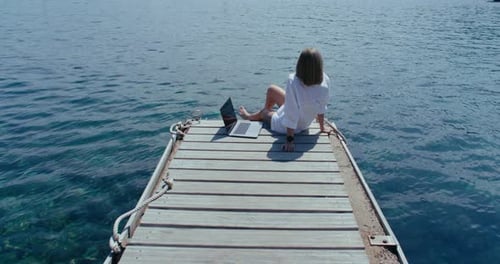 Mulheres com laptop no cais