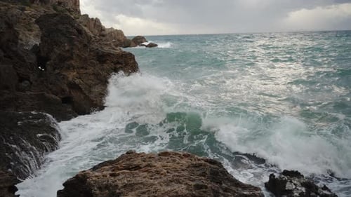 In Slow Motion, a Panorama of a Sea Storm, Waves Crashing Against the Rocks, and Water Sprays Flying