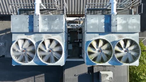 Industrial AC Units with Rotating Fans on Rooftop