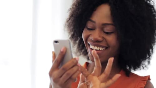 Smiling Woman Using Phone Indoors During the Day