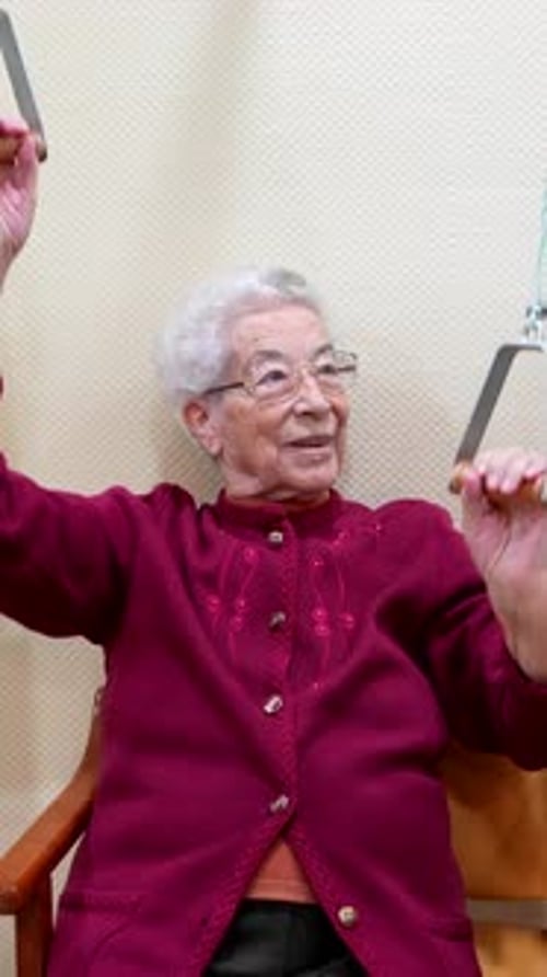 Senior Woman Exercising Arms with Pulley Device