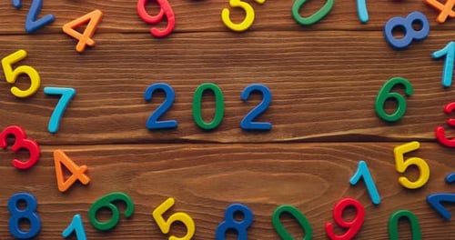 Child Hand Puts Colored Numbers 2023 New Year on Wooden Background