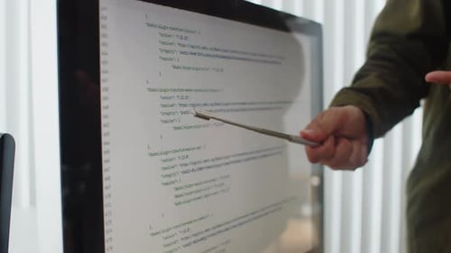Senior Level Developer Teaching New Employees and Pointing at Screen with Code