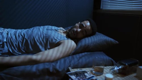 Man Wakes in Bed Looking at Old Photo