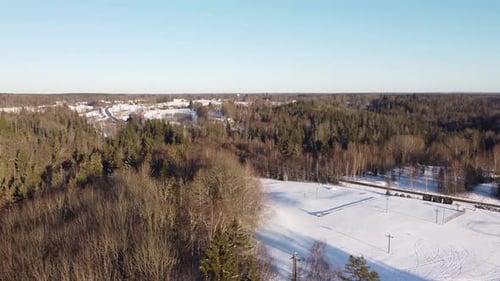 Golden Sunset Over Snowy Forests in Krimulda, Latvia, Aerial Winter View