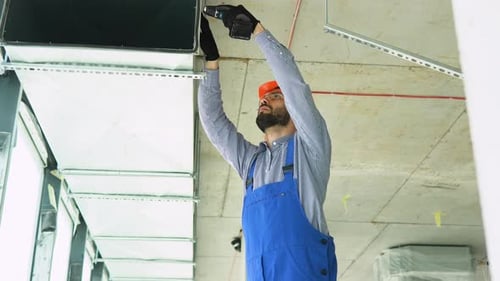 Construction Worker Installing Air Conditioning Vents