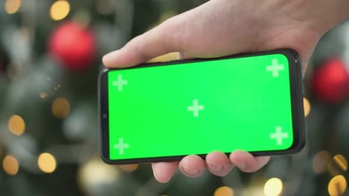 Hand Holding Smartphone with Green Screen on Chroma Key