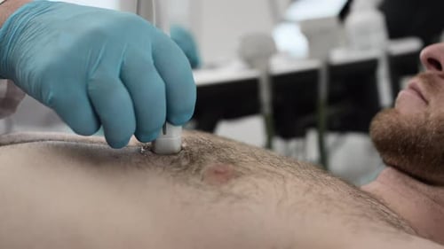 El médico especialista en ultrasonido examina la caja torácica del hombre con una máquina de ultrasonografía