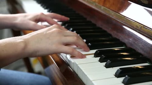 Hands Playing Piano Keyboard in Close Up