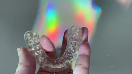 Clear Dental Aligner Shimmers in Hand