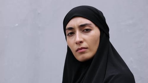 Contemplative Woman in Black Head Covering Gazing Upward