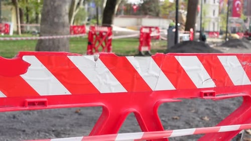 Warning Sign of Repair Work Put Near Striped Red and White Tape Hanging on Sticks