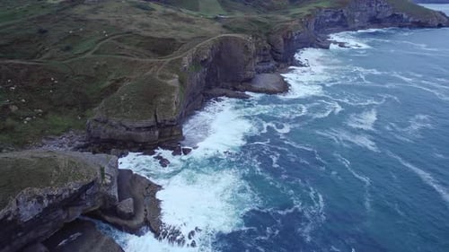 Isla, a stunning island in Cantabria, is covered in green, and the sea is violently crashing against