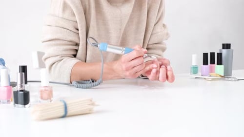 woman doing manicure at home, drilling the nails