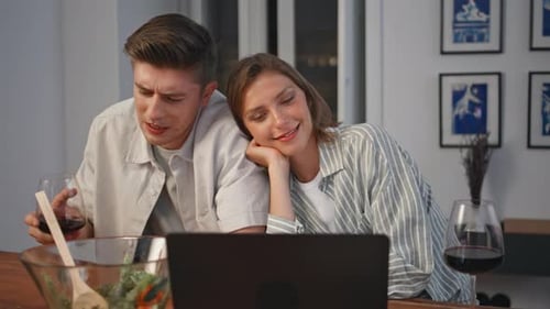 Couple Laughing Together Watching Laptop at Home