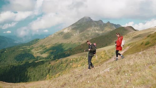 Tourism and Expedition in Mountain Pair of Tourists Walking Together on Slope of High Mount