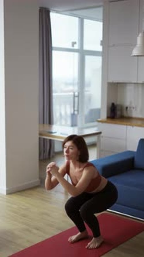 Woman Doing Squat Jumps on a Yoga Mat