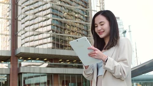 Young Asian Business Woman Professional Standing in City Using Digital Tablet