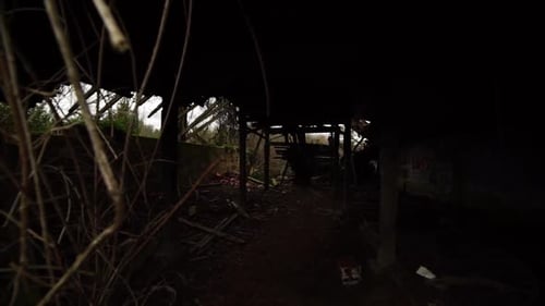 Slow pan from right to left of a condemned and overgrown building at an insane asylum, abandoned, de