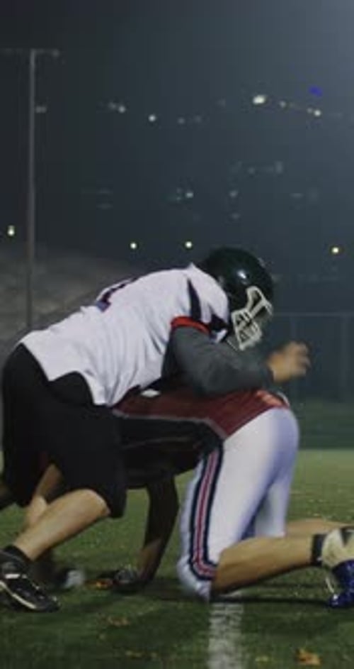 American Football Players Tackling Each Other on Field