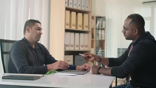 Programmer Exchanging Flash Drive for Envelope with Money