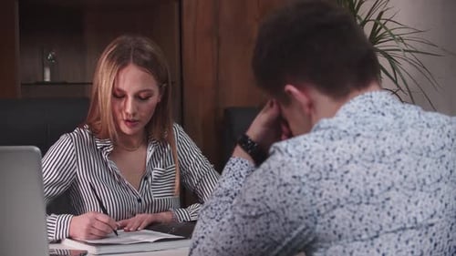 Professional Woman Discussing Business with Man at Desk